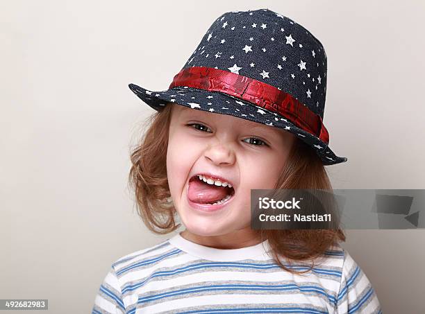 Funny Grimacing Kid In Hat Showing The Tongue Stock Photo - Download Image Now - Cheerful, Child, Cute