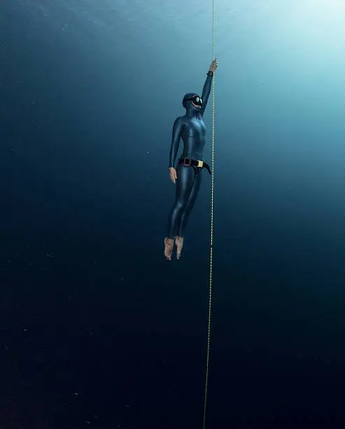 Free diver ascending along the rope. Free immersion discipline