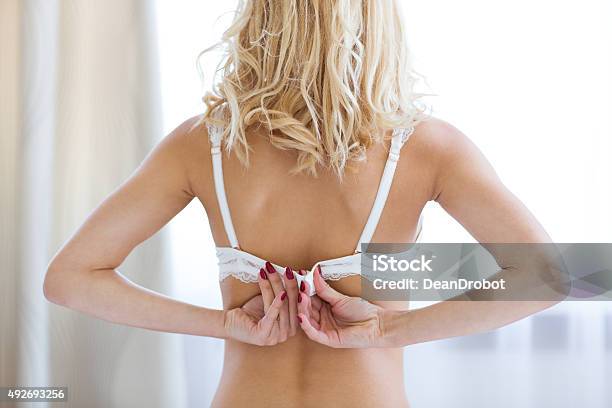 Woman Unbuttoning Brassiere Stock Photo - Download Image Now - Bra, Women, Bed - Furniture