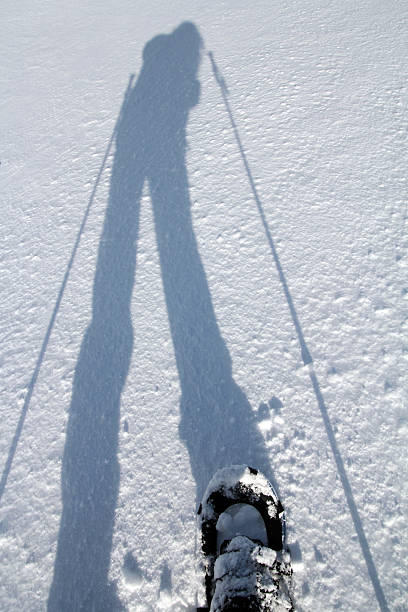 ombra di una camminata con le racchette da neve all'atleta - winter snowshoeing running snowshoe foto e immagini stock