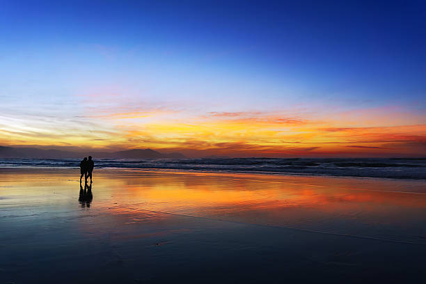 istock couple walking on beach at sunset 492694558