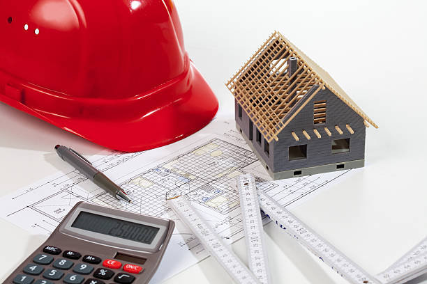 istock Model house folding ruler calculator hard hat pen on blueprint 492694800