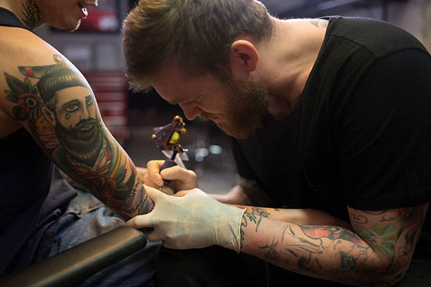 istock Male artist tattooing on man's hand 492697844