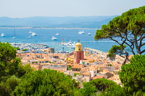 Looking from a viewpoint at the view of the town of Saint Tropez in France. St Tropez is a popular French summer holiday resort. The colour image was taken on a hot summer day. St.-Tropez is a coastal town on the French Riviera, in the Provence-Alpes-Côte d'Azur region of southeastern France. Long popular with artists, the town attracted the international \