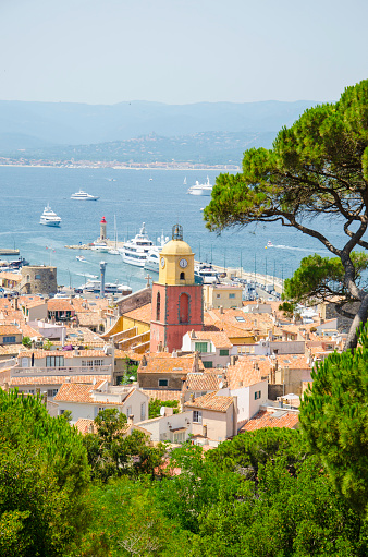 Looking from a viewpoint at the view of the town of Saint Tropez in France. St Tropez is a popular French summer holiday resort. The colour image was taken on a hot summer day. St.-Tropez is a coastal town on the French Riviera, in the Provence-Alpes-Côte d'Azur region of southeastern France. Long popular with artists, the town attracted the international \