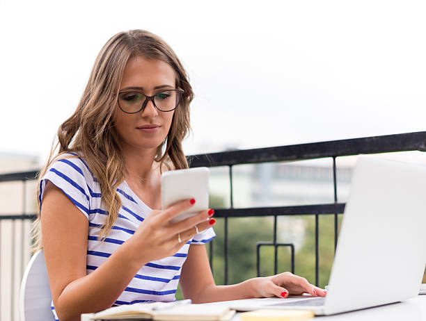 istock Smiling Young woman with mobile phone 492704316