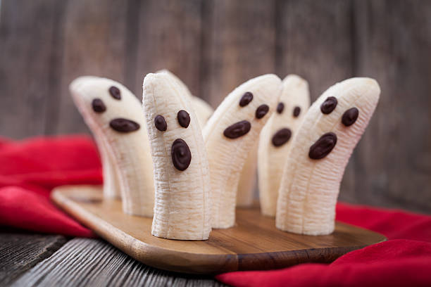 Homemade halloween scary banana ghosts monsters with chocolate faces. Healthy stock photo