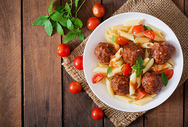 Penne pasta with meatballs in tomato sauce