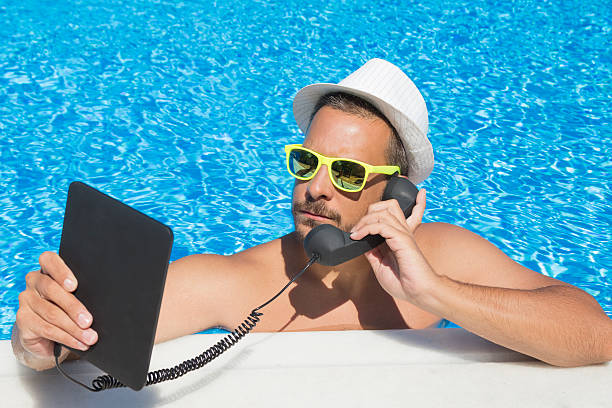 istock Guy having an internet call from the swimming pool 492705368