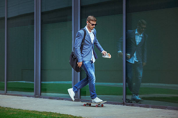 joven empresario informal comuting cómodamente skateboarding. - grave nature usa city life fotografías e imágenes de stock