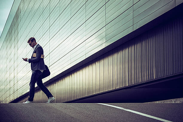 junge lässig geschäftsmann mit smartphone in der urbanen umgebung - reflection businessman business telephone stock-fotos und bilder