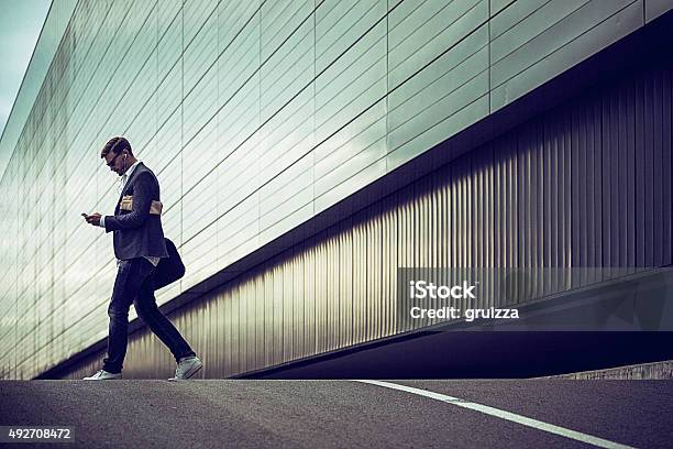 Young Casual Businessman Using Smartphone In The Urban Environment Stock Photo - Download Image Now
