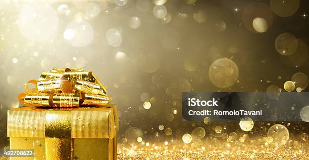 Regalo De Navidad Con El Fondo De Oro Brillante Foto de stock y más banco de imágenes de Regalo de navidad - Regalo de navidad, Dorado - Color, Cumpleaños