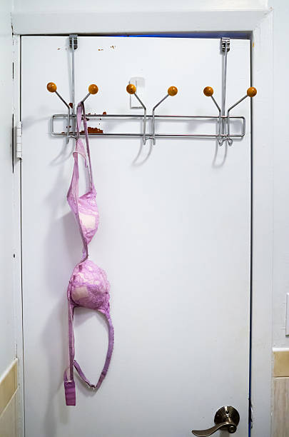Bra Hanging On The Back Of A Bathroom Door Stock Photo - Download