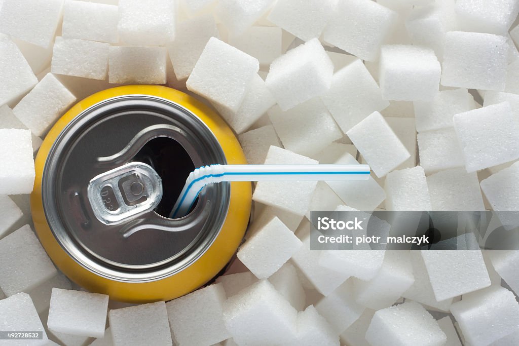 Sugar in food Unhealthy food concept - sugar in carbonated drink. Sugar cubes as background and canned drink Sugar - Food Stock Photo