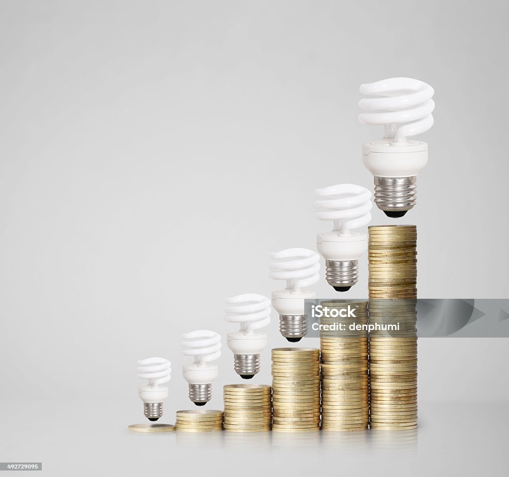 Il denaro risparmiato in diversi tipi di lampadine - Foto stock royalty-free di Affari