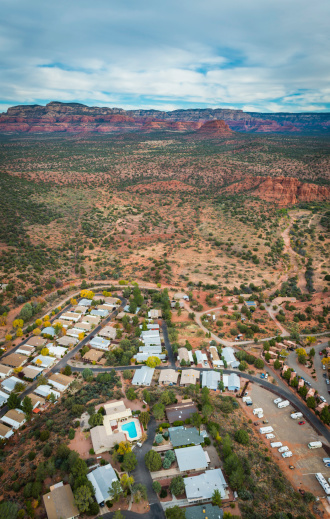 Aerial view over rows of homes curved around neat suburban streets overlooked by red rock landscape of Arizona, USA. ProPhoto RGB profile for maximum color fidelity and gamut.