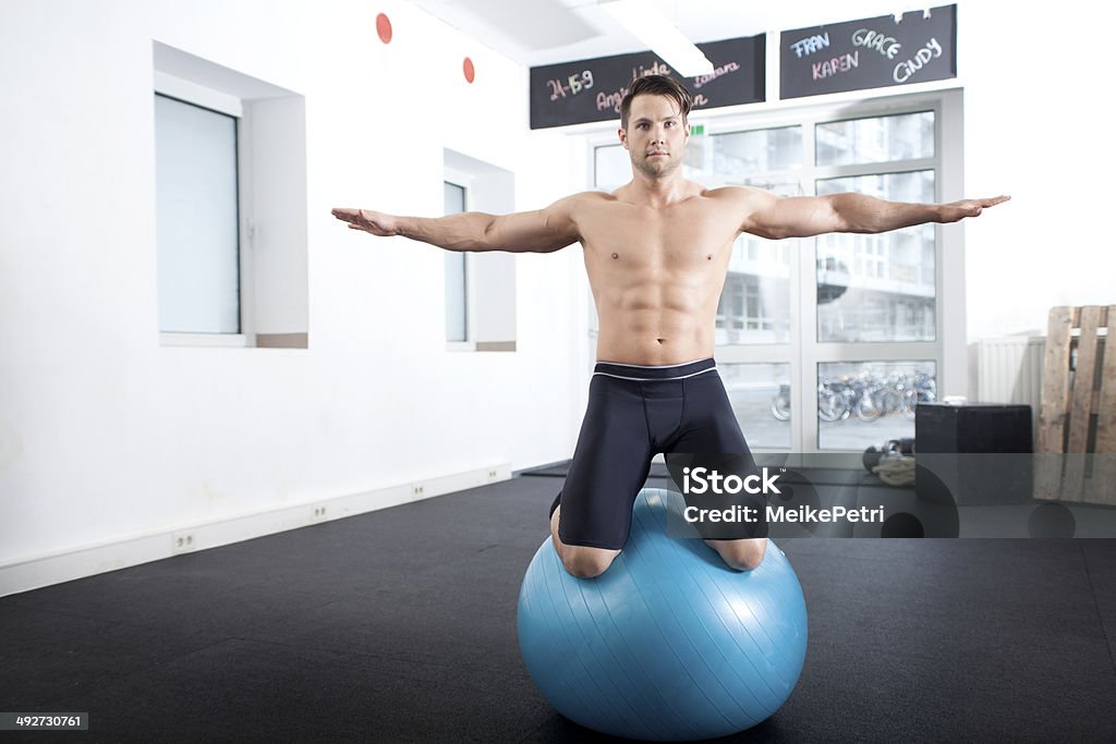 Equilibrio sobre las rodillas con pelota de ejercicio - Foto de stock de Actividades y técnicas de relajación libre de derechos