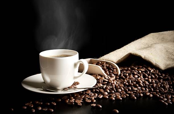 istock Cup of coffee, bag with coffee beans on black desk 492730812