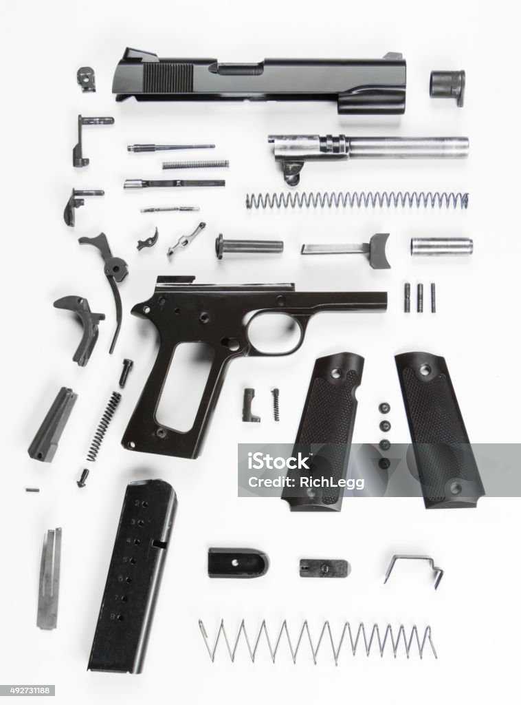 Disassembled Handgun A fully disassembled 20th century military handgun, against a white background. Gun Stock Photo