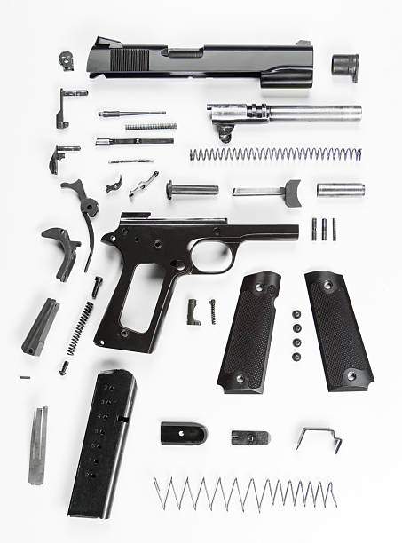 Disassembled Handgun A fully disassembled 20th century military handgun, against a white background. disassembling stock pictures, royalty-free photos & images