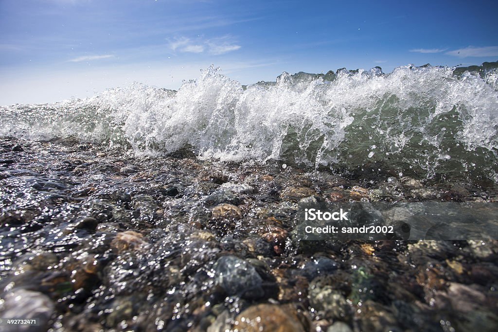 beach coast with stones and blue sky Backgrounds Stock Photo