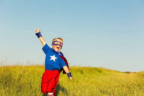 Young Boy dressed as Superhero Raises Arm