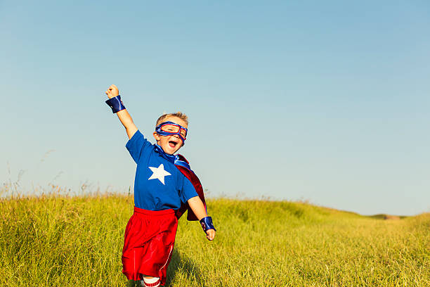 garoto vestido de super-herói eleva o braço - clothing image type childhood nature - fotografias e filmes do acervo