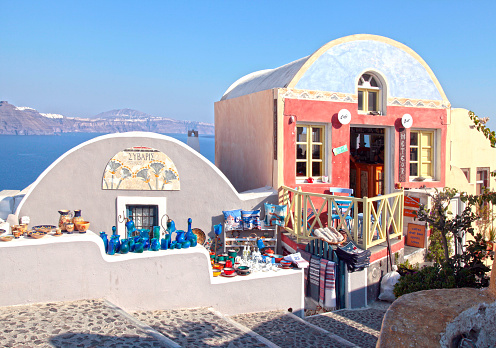 Santorini , Greece - July 27, 2015: Beautiful souvenir shops on typical colorful narrow street in Oia, the most beautiful village of Santorini island, Greece