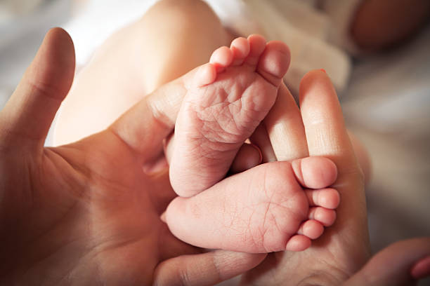 istock Baby feet in mother hands 492733566