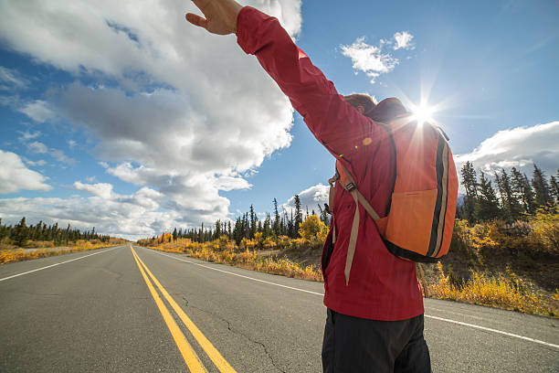istock Man standing on empty road arms outstretched 492752772