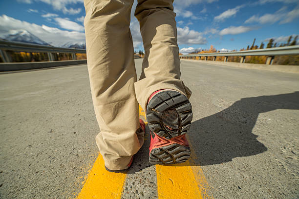 istock Person walking on empty highway-Focus on shoe 492753056