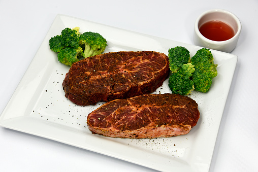 Close-up shot of Juicy Tenderloin Steak With Mix Vegetables and sauce. Filet Mignon steak with diamond grill mark.