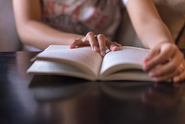 Woman hand on the opened book stock photo