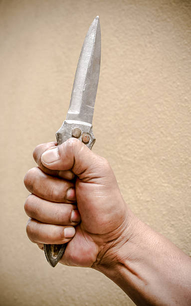 istock Hand holding a knife on yellow background 492756408