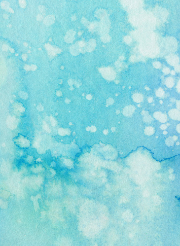 Hand painted blue watercolor background. This abstract painting was created on watercolor paper and has white splatters. This would make a great background texture.