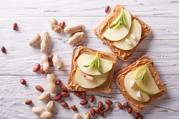 sandwiches with peanut butter and an apple horizontal top view sandwiches with peanut butter and an apple on the table close-up. horizontal top view green apple slice overhead stock pictures, royalty-free photos & images