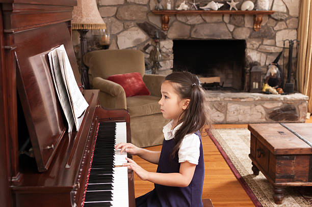 linda menina tocando piano na sua casa - piano sheet music old fashioned classical style - fotografias e filmes do acervo