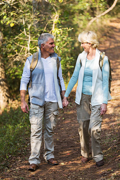 istock mid age couple walking in the forest 492758948
