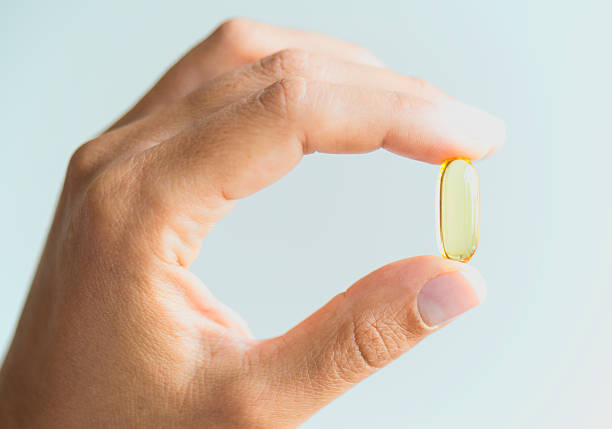istock Woman Holding And Showing Omega 3 Capsule 492759272