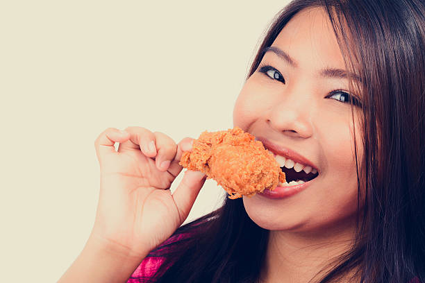 istock Young woman biting fried chicken, vintage tone 492759696