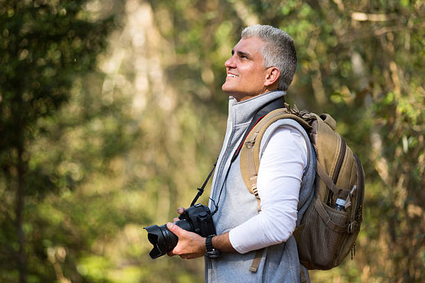 istock man hiking in mountain with dslr camera 492760006