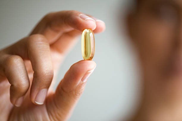istock Woman Holding And Showing Omega 3 Capsule 492760302