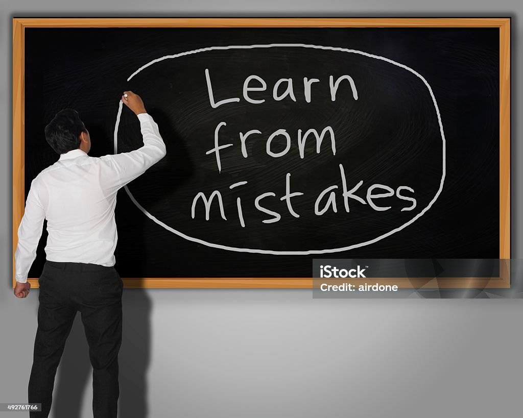 Learn from Mistakes Concept Businessman writing Learn from Mistakes words with chalk on a blackboard in front of him 2015 Stock Photo