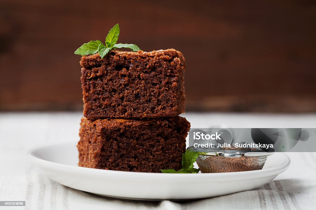 Brownie with mint, closeup chocolate cake or pie, dessert Brownie stack, closeup chocolate cake in plate on rustic wooden table Cake Stock Photo