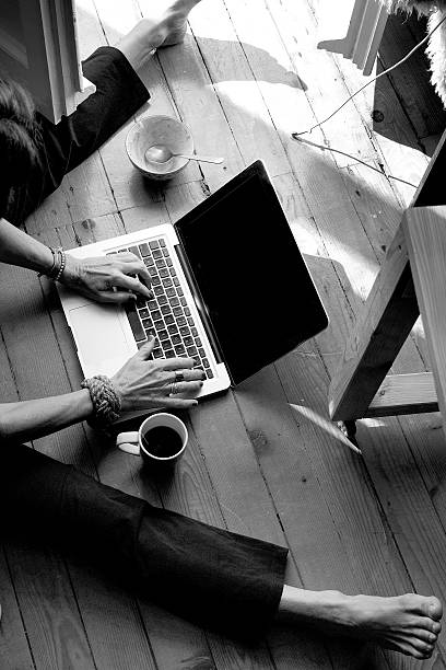 istock Woman Working On The Floor With Laptop Coffee Black White 492764254