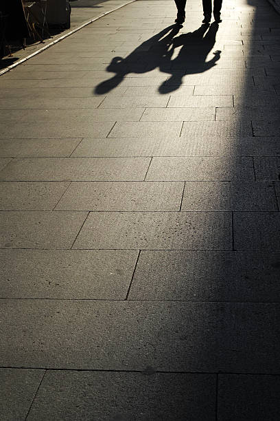 istock Two Humans' Shadows On The Road With Sunlight 492765606
