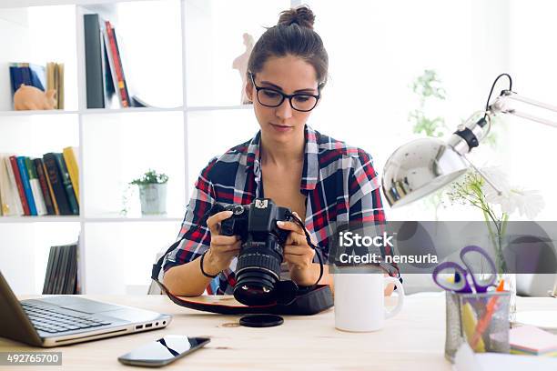 Young Woman Photographer Checking Previews On Camera In The Stud Stock Photo - Download Image Now