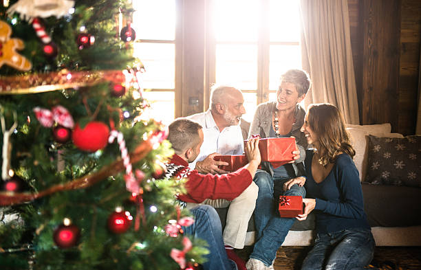 家族とリビングルームでは、クリスマスは exchancing - giving christmas lifestyles holiday ストックフォトと画像