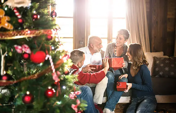 Photo of family on the living room exchancing christmas presents